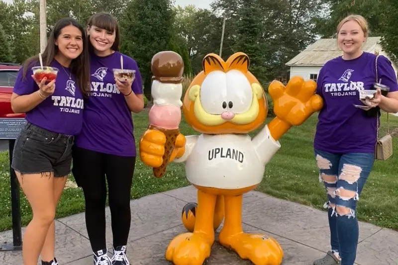 Group of students with a Garfield statue holding ice cream