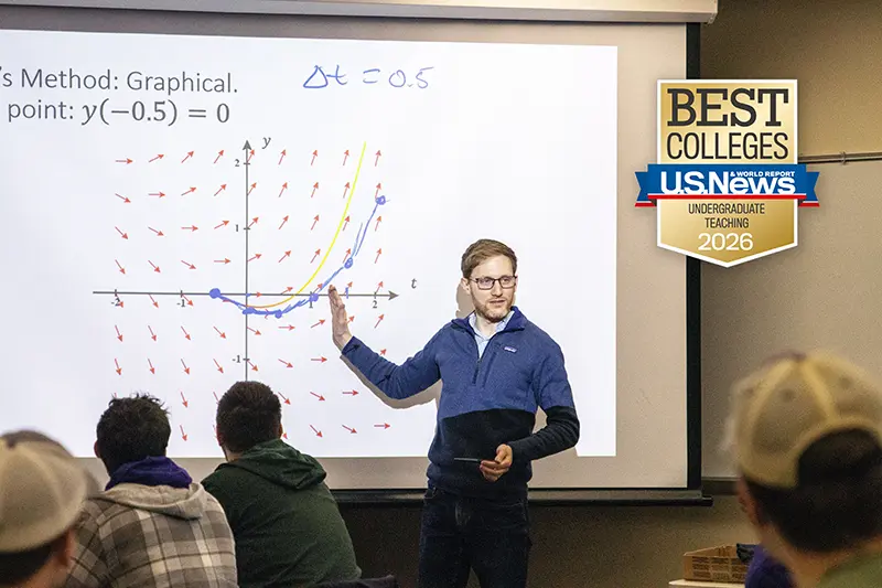 Professor teaching at board with math graph