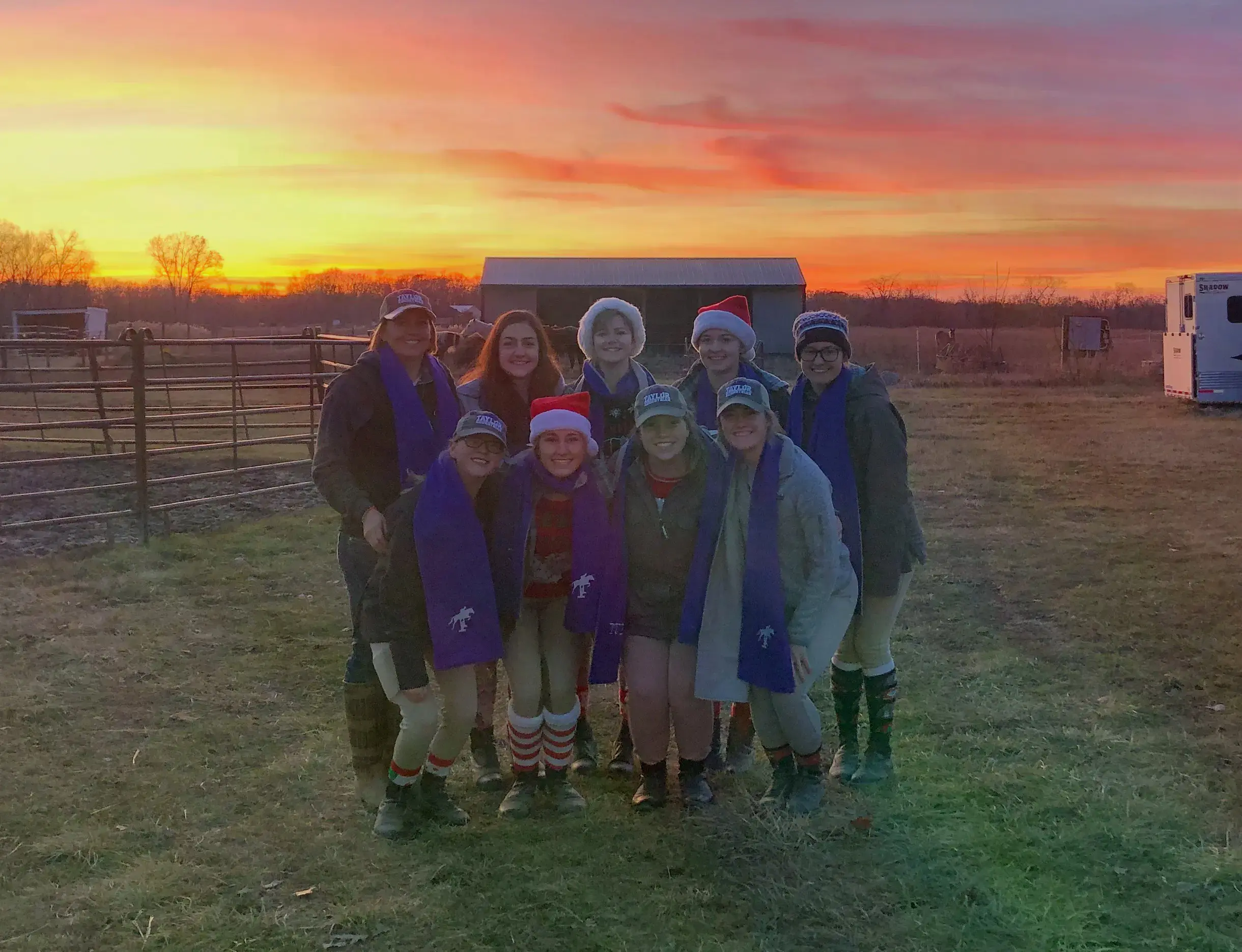 The Equestrian Team standing outside at dusk in scarves