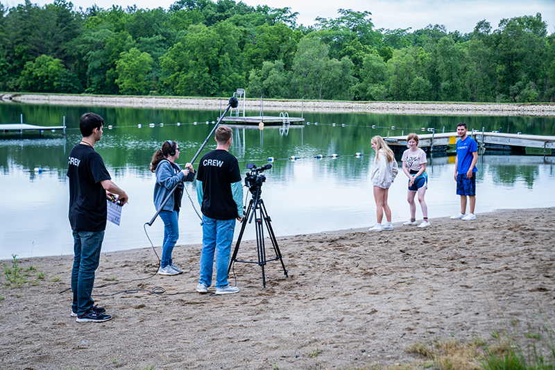 students filming on taylor lake beach