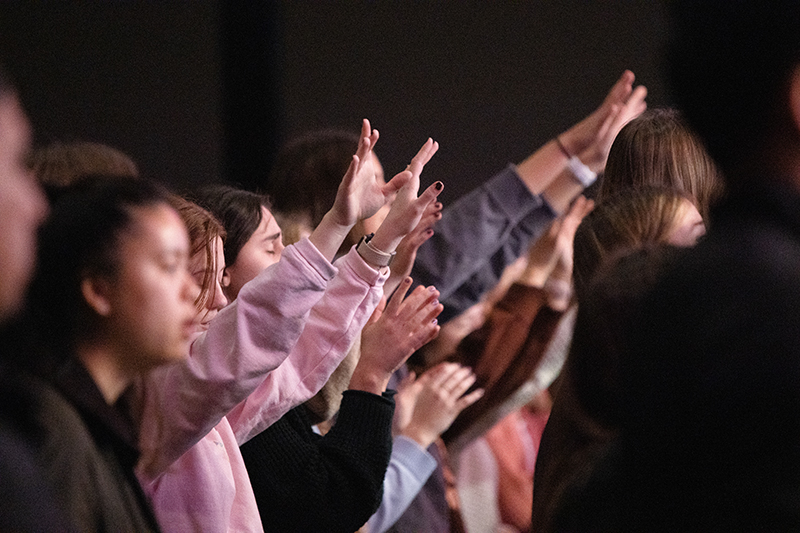 Students raising their hands in worship