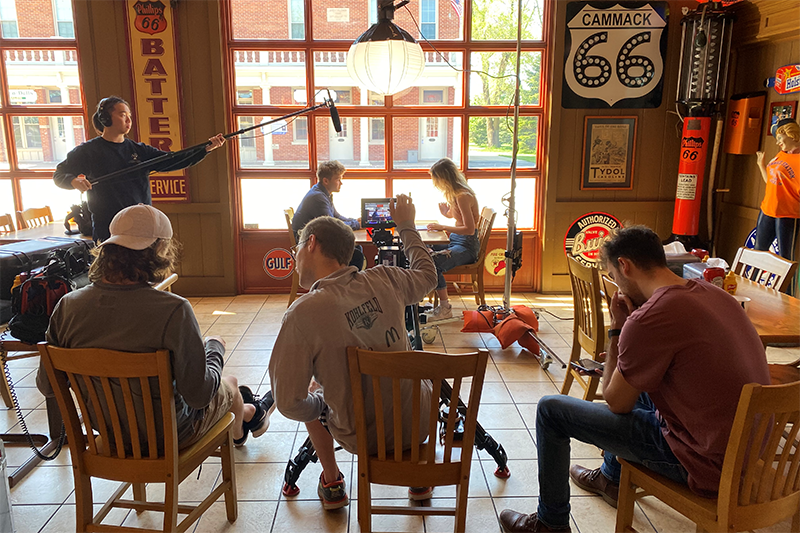 students working on a film in a coffee shop