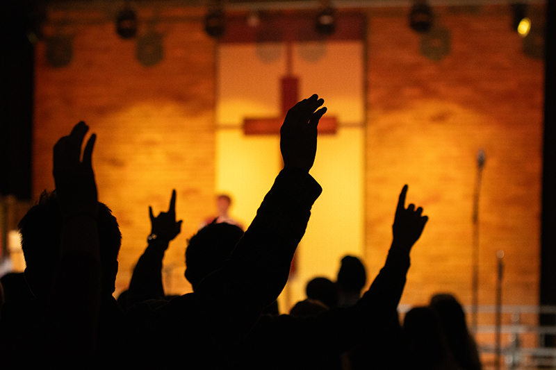 Students raising their hands in worship